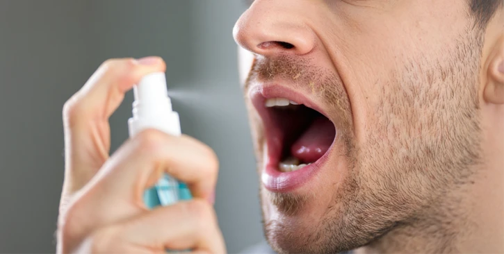 Крупный план мужчины со спреем для рта
