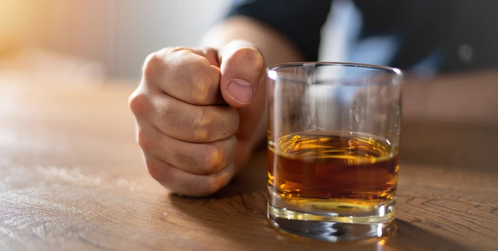 Бокал и сжатый кулак на столе